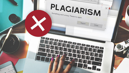 woman typing on laptop with plagiarism warning