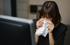 Businesswoman blowing nose
