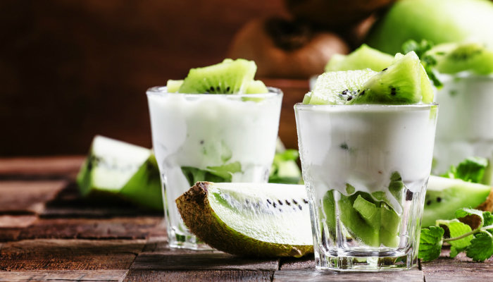 A close-up of glasses with yoghurt and kiwi fruit
