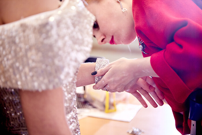 Costume designer adding a bracelet to an outfit