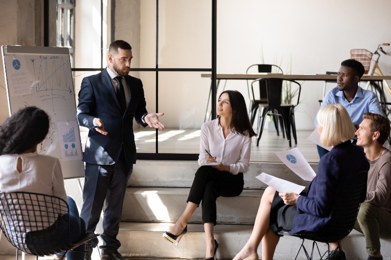 CFO standing in front of a white board and a group of employees