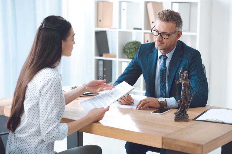 Lawyer sitting at his desk faced with a female employee