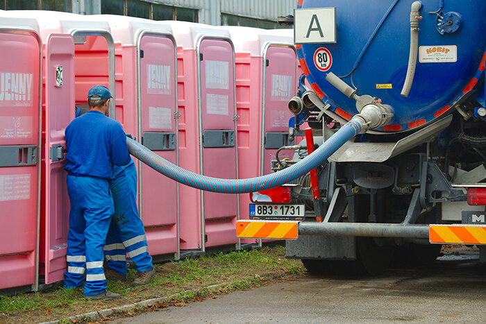 Portable toilet cleaners pumping out portable toilets.