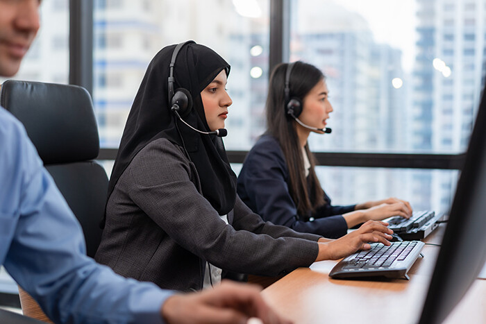 Customer service advisors in an office awaiting calls from customers.