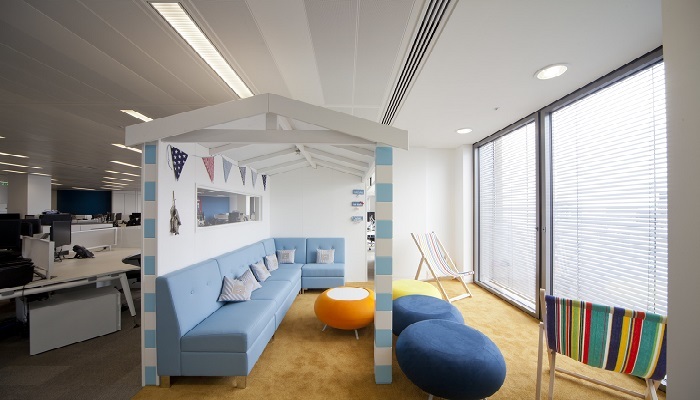 A modern office with a light blue corner sofa